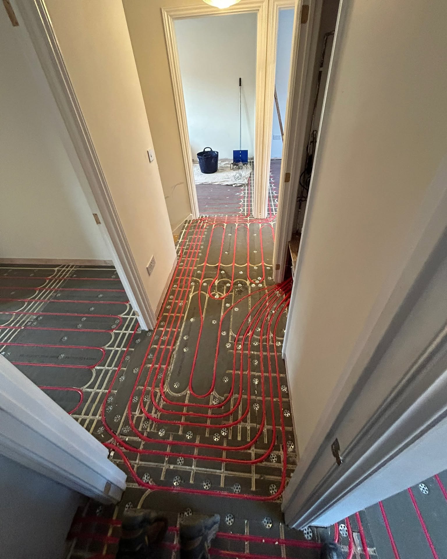 Wet underfloor heating pipe loops installed across a large family kitchen