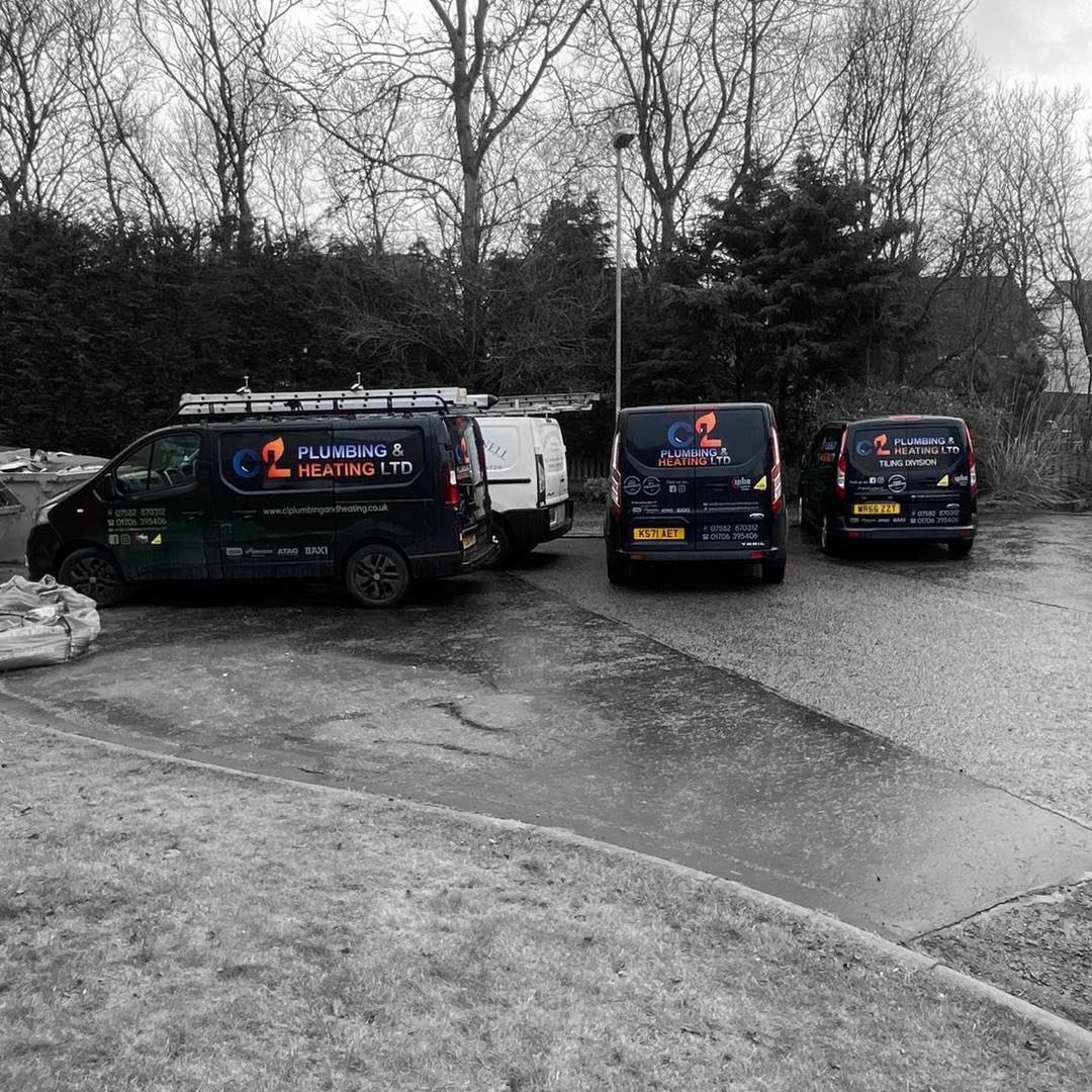 Our branded plumbing and heating vans lined up on a Greater Manchester job